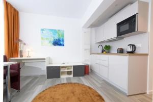eine Küche mit weißen Schränken und einer Arbeitsplatte in der Unterkunft Huber Living Single 301 in Germering