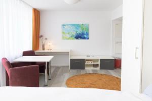 ein weißes Zimmer mit einem Tisch, einem Tisch und Stühlen in der Unterkunft Huber Living Single 301 in Germering