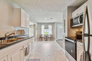 a kitchen with a sink and a microwave at ~ Modern and Cozy 4BR home - 30 Mins from Disney ~ in Orlando