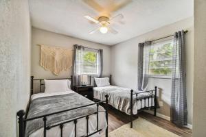 a bedroom with two beds and a ceiling fan at ~ Modern and Cozy 4BR home - 30 Mins from Disney ~ in Orlando
