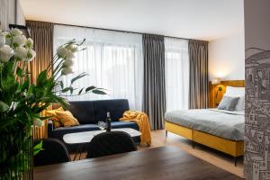 um quarto de hotel com uma cama e um sofá em Aparthotel InPoint Cracow G15 - Free Underground Parking em Cracóvia