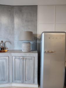 uma cozinha com um frigorífico e um candeeiro em cima em Raízes Turismo Rural em Castelo Branco