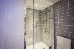 a bathroom with a shower with a glass door at Holiday Inn Express - Stockport by IHG in Stockport +24 photos