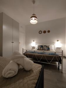 a white bedroom with two beds and a light fixture at Oltre la Vite in Selva di Fasano