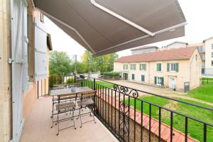 een patio met een tafel en stoelen op een balkon bij La Dolive - Locationtournus in Tournus