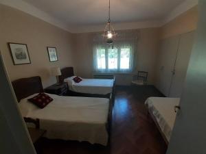 a hotel room with two beds and a window at Amplia Casona de Estilo en La Falda in La Falda