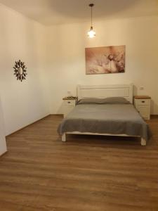a bedroom with a bed and a painting on the wall at Han Dunarea in Călăraşi +5 photos