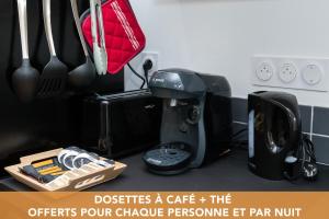 - un comptoir de cuisine avec une cafetière et des ustensiles dans l'établissement La Dolive - Locationtournus, à Tournus