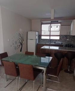 een keuken met een tafel en stoelen en een koelkast bij Departamento Playas Villamil vacaciones in Playas