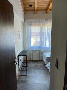 a room with a bed and a table and a window at AIKEN 19 in San Martín de los Andes