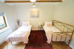 1 Schlafzimmer mit 2 Betten und einem Teppich in der Unterkunft East Lodge in Bolney