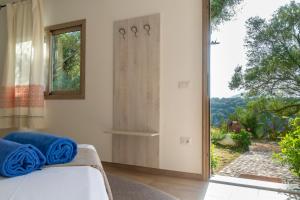 a bedroom with a bed and a large window at Hotel Villa Cedrino in Dorgali