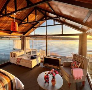a living room with a view of the water at KAY PACHA LODGE lago titicaca All Inclusive in Puno