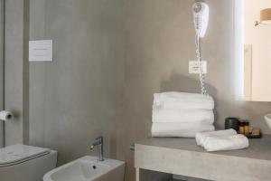 a bathroom with a pile of towels on a counter at Hotel Villa Cedrino in Dorgali