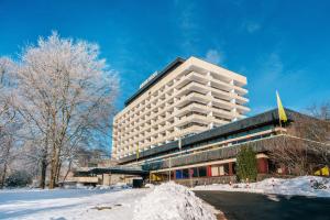 un grand bâtiment avec de la neige devant lui dans l'établissement AHORN Harz Hotel Braunlage, à Braunlage