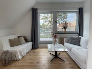 ein Wohnzimmer mit einem weißen Sofa und einem Tisch in der Unterkunft Wasserblick Stadtidyll 3 Zimmer Apartment Lübeck in Lübeck