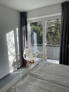 1 dormitorio con 1 cama y 1 silla frente a una ventana en Wasserblick Stadtidyll 3 Zimmer Apartment Lübeck, en Lübeck