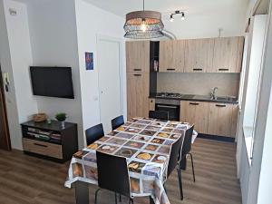 mesa de comedor con sillas y cocina en Residence Avila en Gallio
