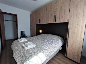 Schlafzimmer mit einem großen Bett und Holzschränken in der Unterkunft Residence Avila in Gallio