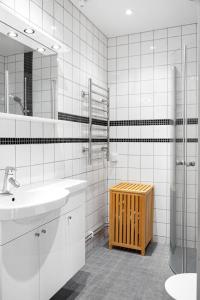 a white bathroom with a sink and a mirror at Windalens på Österlen in Tomelilla