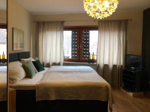 a bedroom with a large bed and a chandelier at Gästehaus Susanne Pfaffmann in Landau in der Pfalz