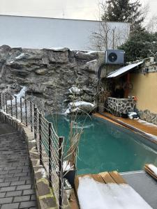 een zwembad met een stenen muur naast bij AbC in Unhošť