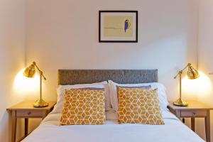 a bedroom with a bed with two lamps on tables at Calabria 4 Comfortable apartment in London