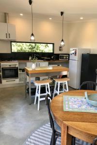 eine Küche mit Holztischen und weißen Geräten in der Unterkunft Sinclair Eco House in Port Lincoln