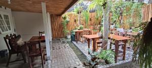 eine Terrasse mit Tischen und Stühlen und einem Zaun in der Unterkunft The Bloomy House in Yogyakarta