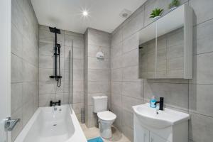 a bathroom with a sink and a toilet and a tub at 3 Anzac Cottage in Cowes +10 photos