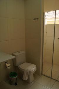 a bathroom with a toilet and a shower at Ipê Rosa Hotel in Bauru