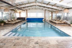 a swimming pool with blue water in a building at The White Chalet View in Moshav Ramot