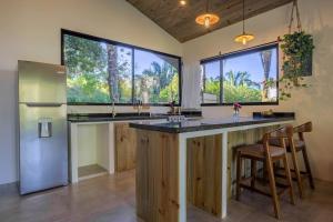 a kitchen with a large island and two windows at The Surf Journey Casita in Uvita