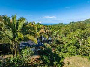 an aerial view of a resort with palm trees and the ocean at The Surf Journey Casita in Uvita