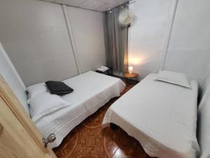a small room with two beds and a black bag on top at Casa Congo in Golfito