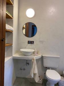 a bathroom with a sink and a toilet and a mirror at Casa en Camino del cuadrado Sierras de Córdoba in Río Ceballos