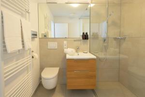 a bathroom with a toilet sink and a shower at Huber Living Basic 102 in Germering