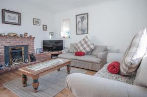 ein Wohnzimmer mit einem Sofa und einem Kamin in der Unterkunft Maytree Cottage - 4 Bedroom Holiday Home - Tenby in Tenby