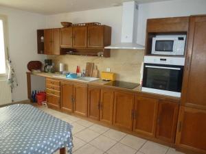 cocina con armarios de madera y microondas en Gite de la Sèvre en Saint-Amand-sur-Sèvre