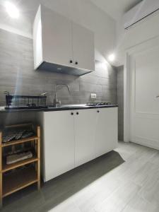 a kitchen with white cabinets and a sink at Oltre la Vite in Selva di Fasano