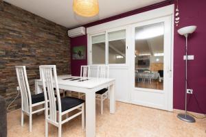 a dining room with a white table and chairs at Casa Gratal in Siétamo