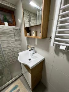 a white bathroom with a sink and a shower at Vila Vodice Zlatibor in Vodice