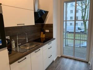 eine Küche mit einem Waschbecken und einem großen Fenster in der Unterkunft 40 qm Appartment Parkplatz, Balkon,Netflix, Prime in Chemnitz
