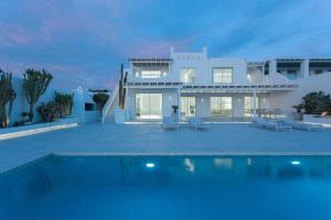 uma casa branca com uma piscina em frente em Super Luxury Mykonos Villa - Villa Saorsa - 5 Bedroom - Infinity Pool - Panoramic Sea Sunset Views em Dexamenes