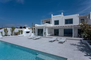 une villa avec une piscine à côté d'une maison dans l'établissement Super Luxury Mykonos Villa - Villa Saorsa - 5 Bedroom - Infinity Pool - Panoramic Sea Sunset Views, à Dexamenes