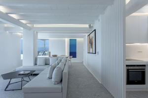 un soggiorno bianco con divano e tavolo di Super Luxury Mykonos Villa - Villa Saorsa - 5 Bedroom - Infinity Pool - Panoramic Sea Sunset Views a Dexamenes