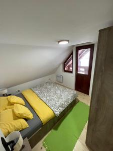 ein kleines Schlafzimmer mit einem Bett und einem grünen Teppich in der Unterkunft Vila Vodice Zlatibor in Vodice