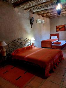 a bedroom with two beds with red sheets at Riad Ain Khadra in Taroudant