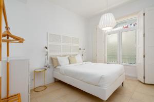 a white bedroom with a white bed and a window at Setúbal Downtown Apartments in Setúbal
