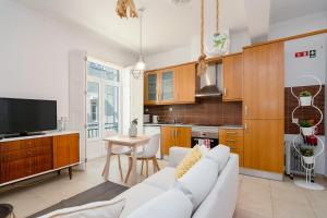 a living room with a white couch and a kitchen at Setúbal Downtown Apartments in Setúbal